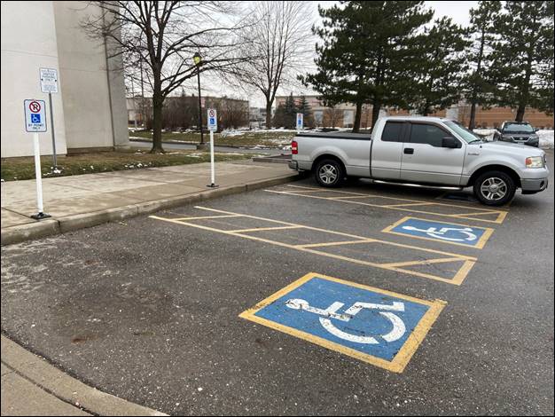 Schedule A - Two accessible parking spaces, and a vehicle parked in a third parking space. 